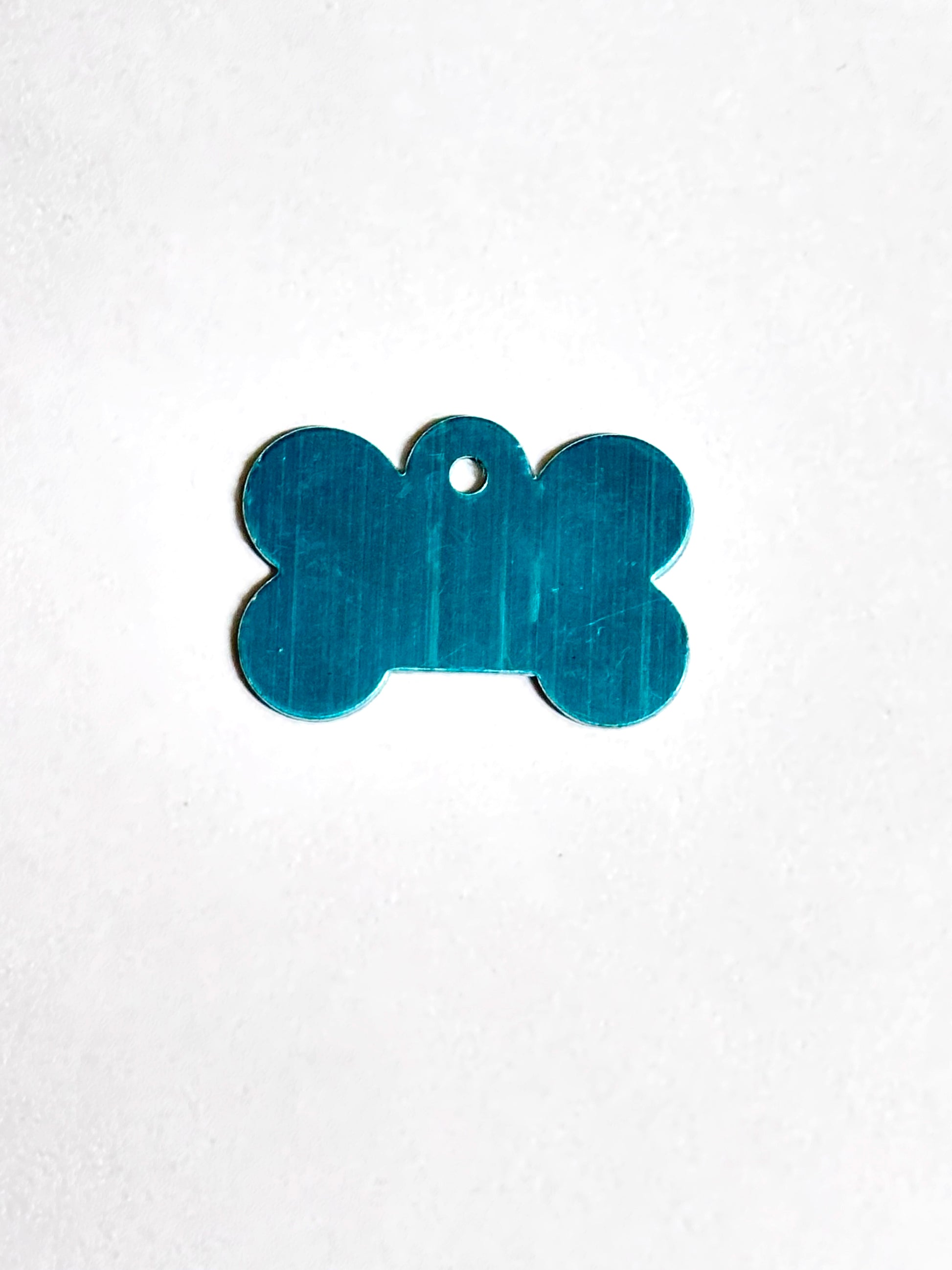 silver bone-shaped tag on a white background