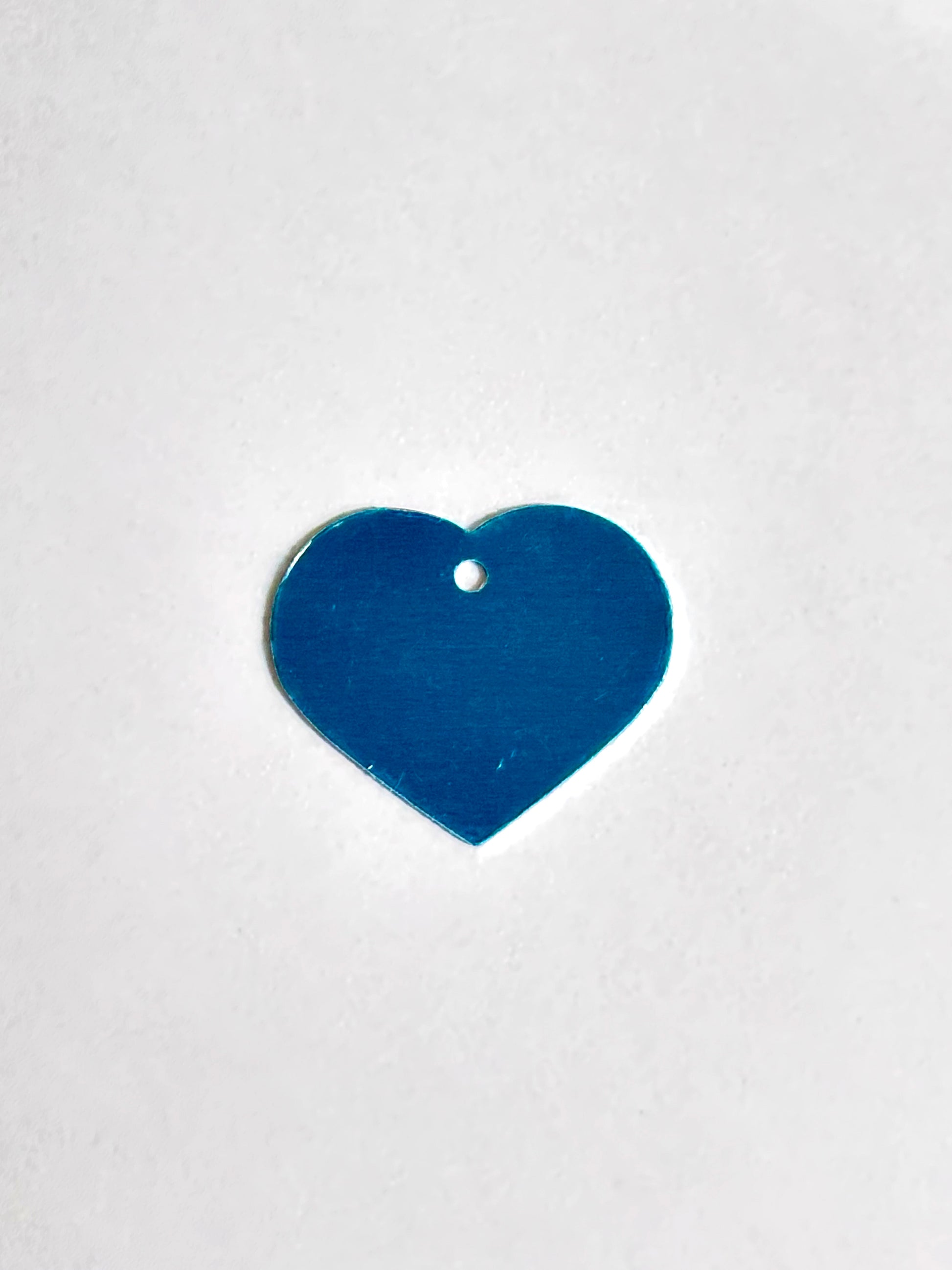 silver heart-shaped object on a white background