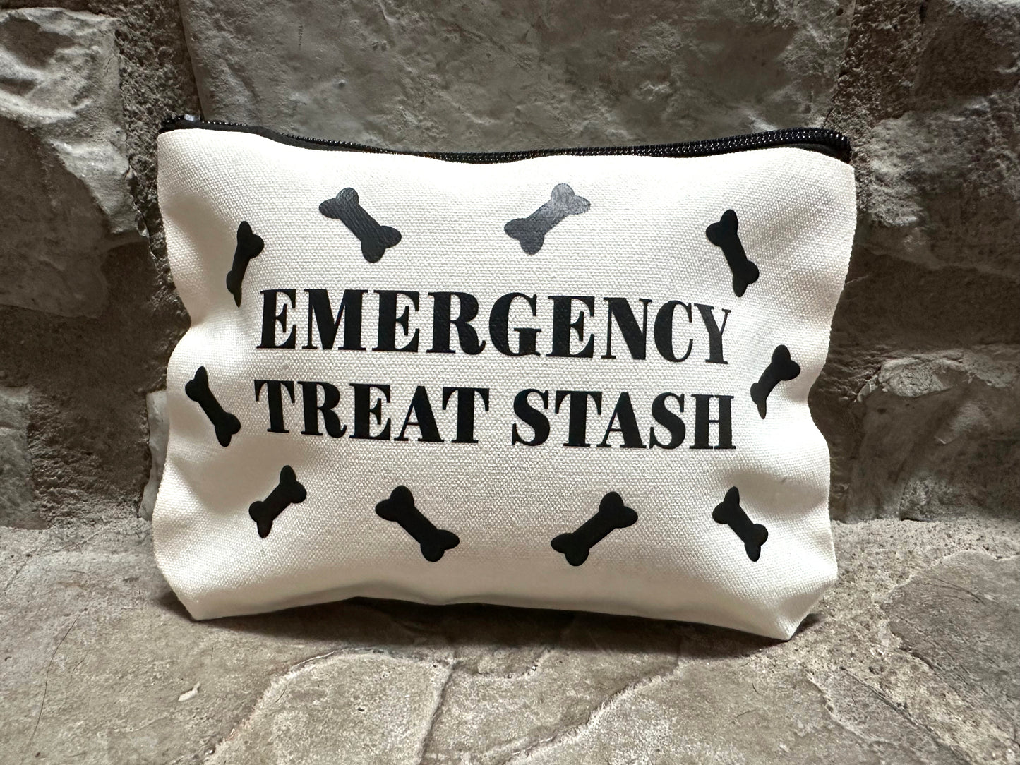canvas pouch with 'Emergency Treat Stash' text and black bones on a stone surface